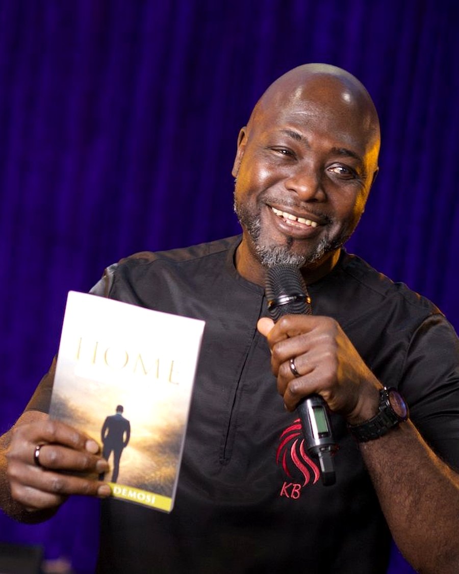 Kunle speaking and holding The Long Way Home